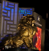 a large golden statue of a lion in front of a building