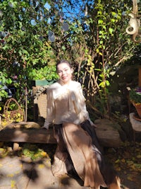 a woman sitting on a wooden bench