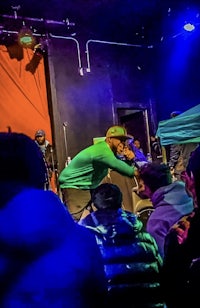 a man on stage with a microphone in front of a crowd