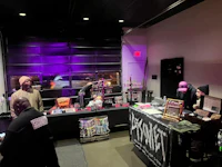 a group of people standing around a table with purple lights