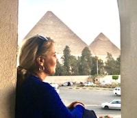 a woman looking out of a window at the pyramids
