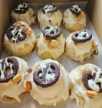 a box of cinnamon rolls with chocolate and pretzels