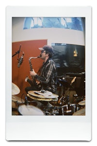 a man playing a saxophone in a recording studio