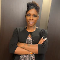 a black woman with her arms crossed posing for a photo