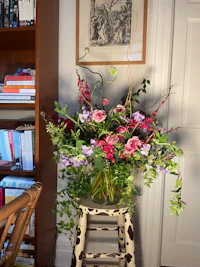 a vase of flowers sitting on a chair in a room