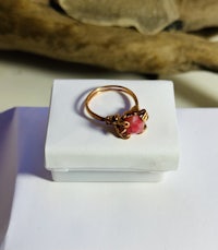 a ring with a pink stone sitting on top of a box
