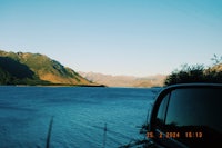 a view of a lake from the side of a car