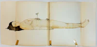 an open book with a drawing of a woman laying down