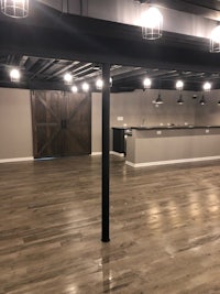 an empty basement with wood floors and a bar