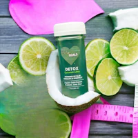 a bottle of coconut oil with limes and a measuring tape