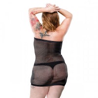 a woman in a black fishnet dress with tattoos