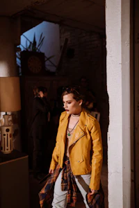 a woman in a yellow jacket walking down a hallway