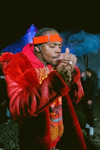 a man in a red jacket smoking a cigarette