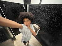 a young boy taking a selfie in a bathroom
