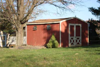 a red shed in a grassy area