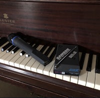 a microphone sits on top of a piano
