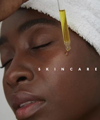 a woman is applying a serum to her face