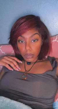 a woman with red hair laying on a bed