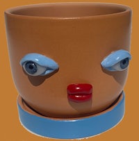 a ceramic planter with a face on it