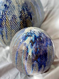 two blue and white spheres on a white surface