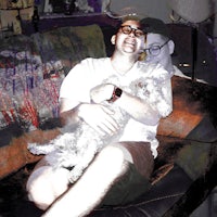 a man sitting on a couch with a dog