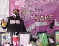 a woman standing in front of a table with products