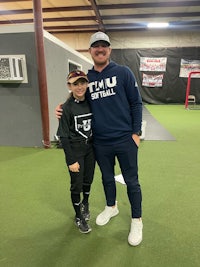 a man and a boy posing for a picture in a baseball field