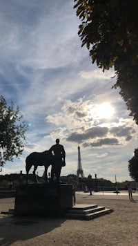 a statue of a man and a horse in front of the eiffel tower