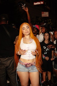 a woman with orange hair posing in front of a crowd