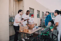 a group of people standing around a table with boxes