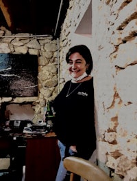 a woman standing in a room with a bottle of wine