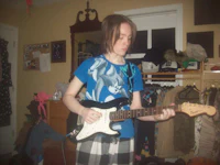 a girl playing an electric guitar in a room