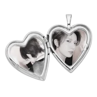 a heart shaped locket with two pictures in it