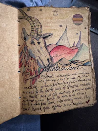 a notebook with a drawing of a goat on it
