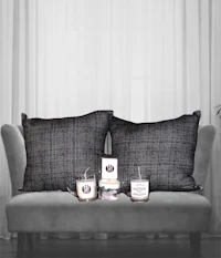a grey couch with pillows and candles on it