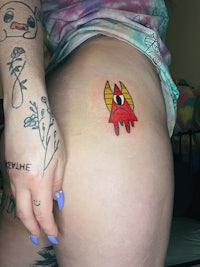 a woman with a tattoo of a space alien on her butt