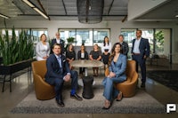 a group of business people posing for a photo in an office