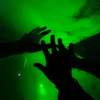 two hands reaching for each other in a green light