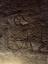 an egyptian statue of a man riding a bicycle
