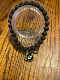 a black lava stone bracelet on a wooden table