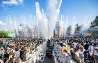 a crowd of people watching a water show at an outdoor event