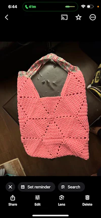 a pink crocheted bag on a table