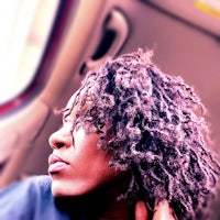 a woman with dreadlocks sitting in a car