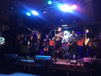a group of people in kilts on stage at a bar