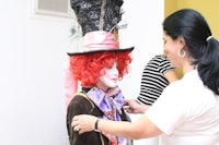 a woman is putting on a mad hatter hat