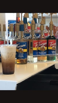 a glass of iced coffee sitting on a counter