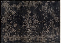 a black and beige rug with an ornate design