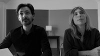 a black and white photo of a man and woman sitting at a table