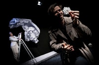 a man holding a snowflake in front of a stage