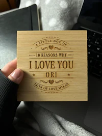 a person holding up a wooden card that says i love you